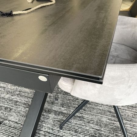 Grauer Tisch mit einem grauen Stuhl steht auf einem grauen Teppich