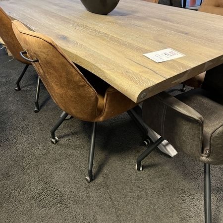 Tisch mit einer massiven Echtholzplatte und braunen Stühlen steht im Ausstellungsraum
