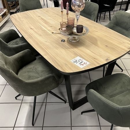Holztisch mit grauen Stühlen steht im Ausstellungsraum
