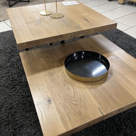 Ein zweiteiliger Couchtisch aus Holz steht auf einem Teppich
