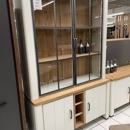 Ein weißer Holzschrank mit Vitrine und zwei Schranktüren