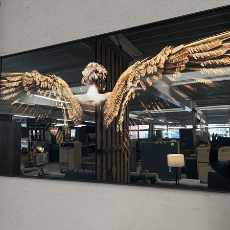 Ein großes, glänzendes Bild eines Rückens mit Flügeln hängt an einer Wand im Verkaufsraum