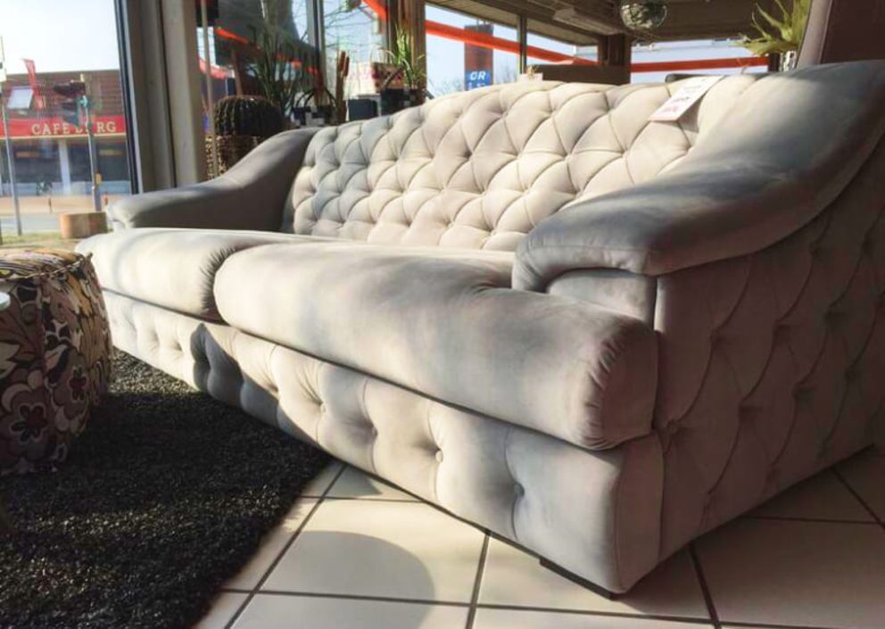 Eine cremefarbene Couch steht in einem Ausstellungsraum